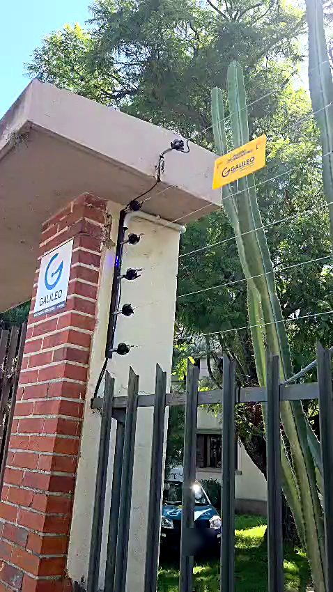 Cerco eléctrico en pilar de entrada con cartel de Galileo