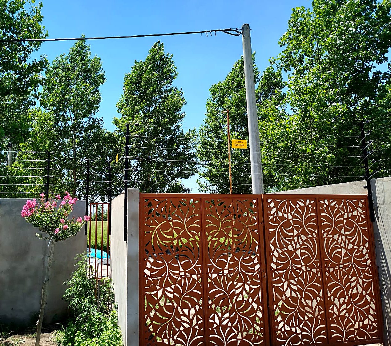 Cerco eléctrico instalado sobre muro y portón de casa con parque